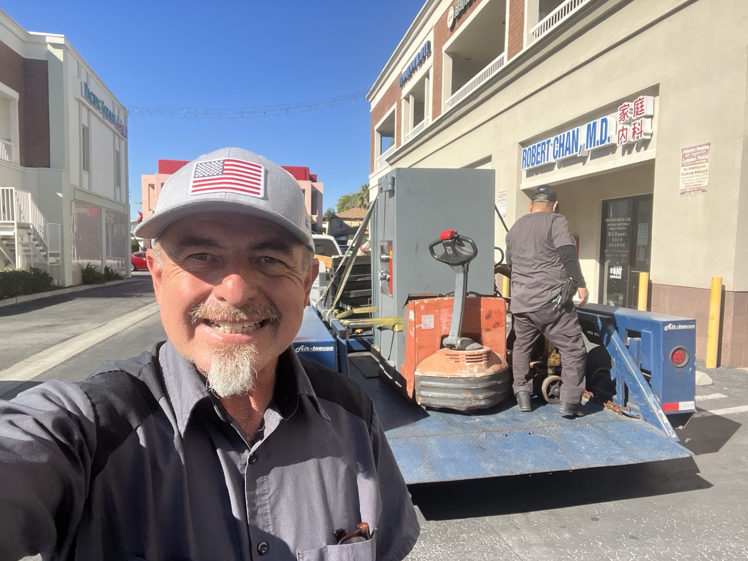 Jose Velasco of Velasco Lock and Safe with a team member and a safe on the moving trailer